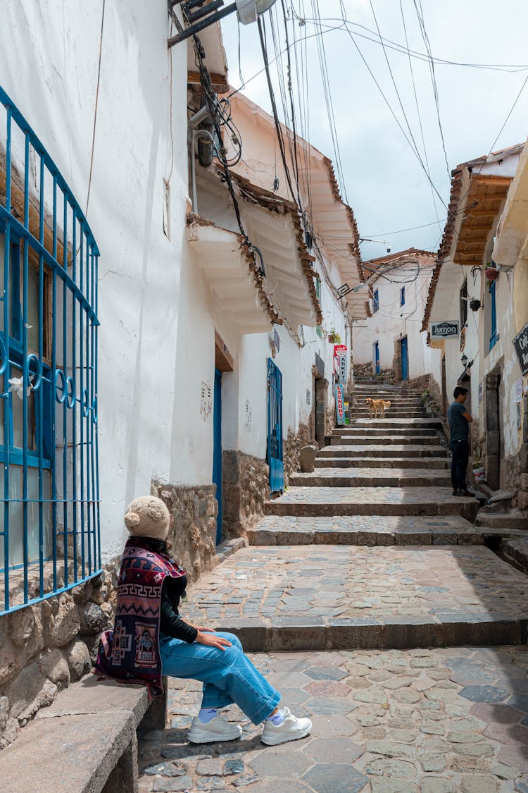 Woman Sitting In Alley In Town