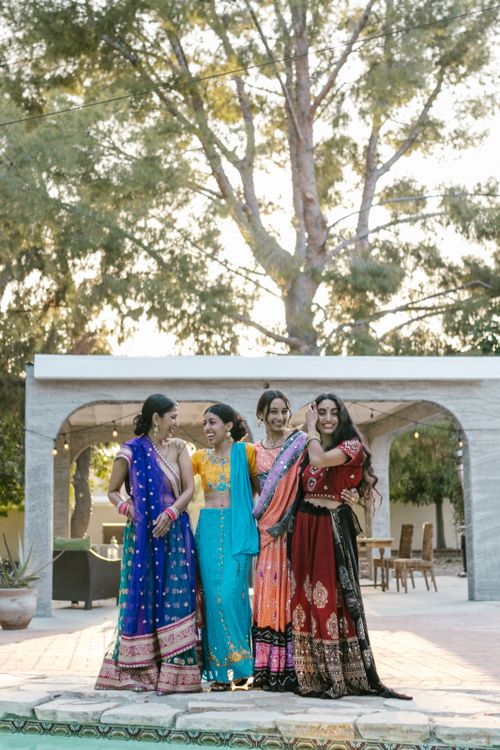 Free Group of South Asian women in colorful traditional attire enjoying an outdoor celebration. Stock Photo