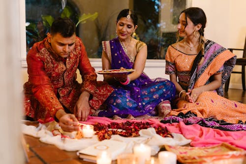 Free A Man and Women Sitting Together Offering a Plate Stock Photo