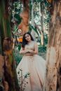 Woman in White Wedding Gown Standing Beside Brown Tree
