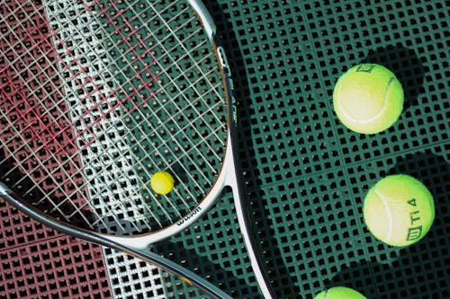 Free A Top View of  a Tennis Racket Beside Tennis Balls Stock Photo