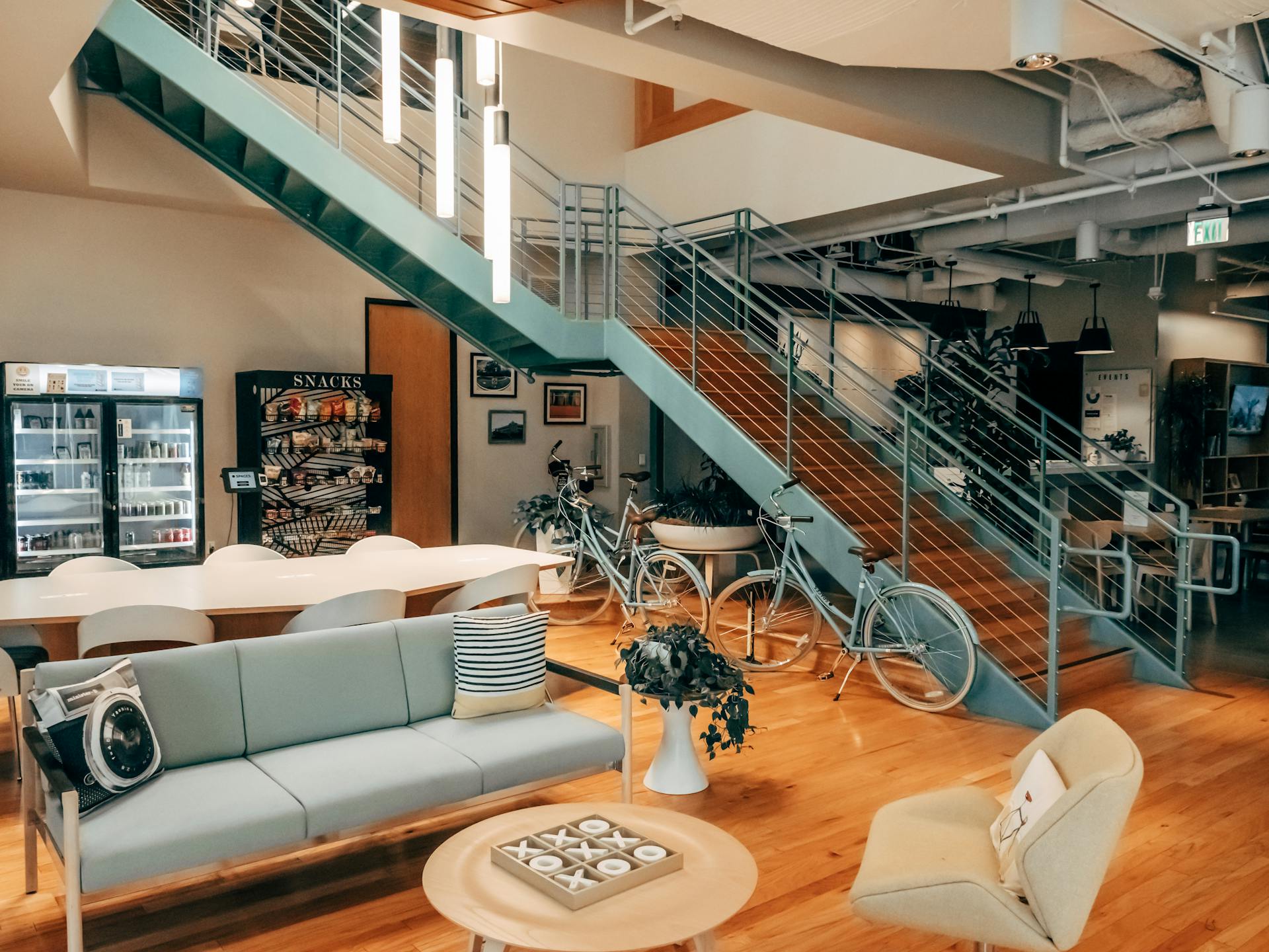 Bright and modern open office space featuring bikes, cozy seating, and stylish interior design elements.