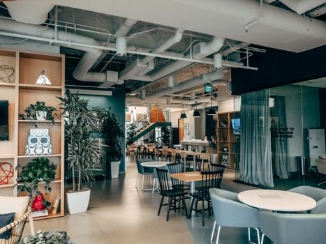 Spacious contemporary office lounge featuring stylish furniture and indoor greenery.
