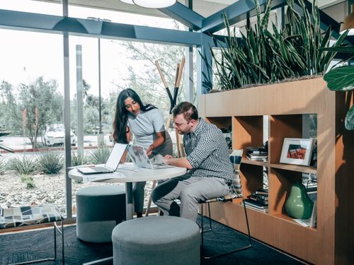 Free Two colleagues engaging in a project meeting in a modern office space with natural light. Stock Photo