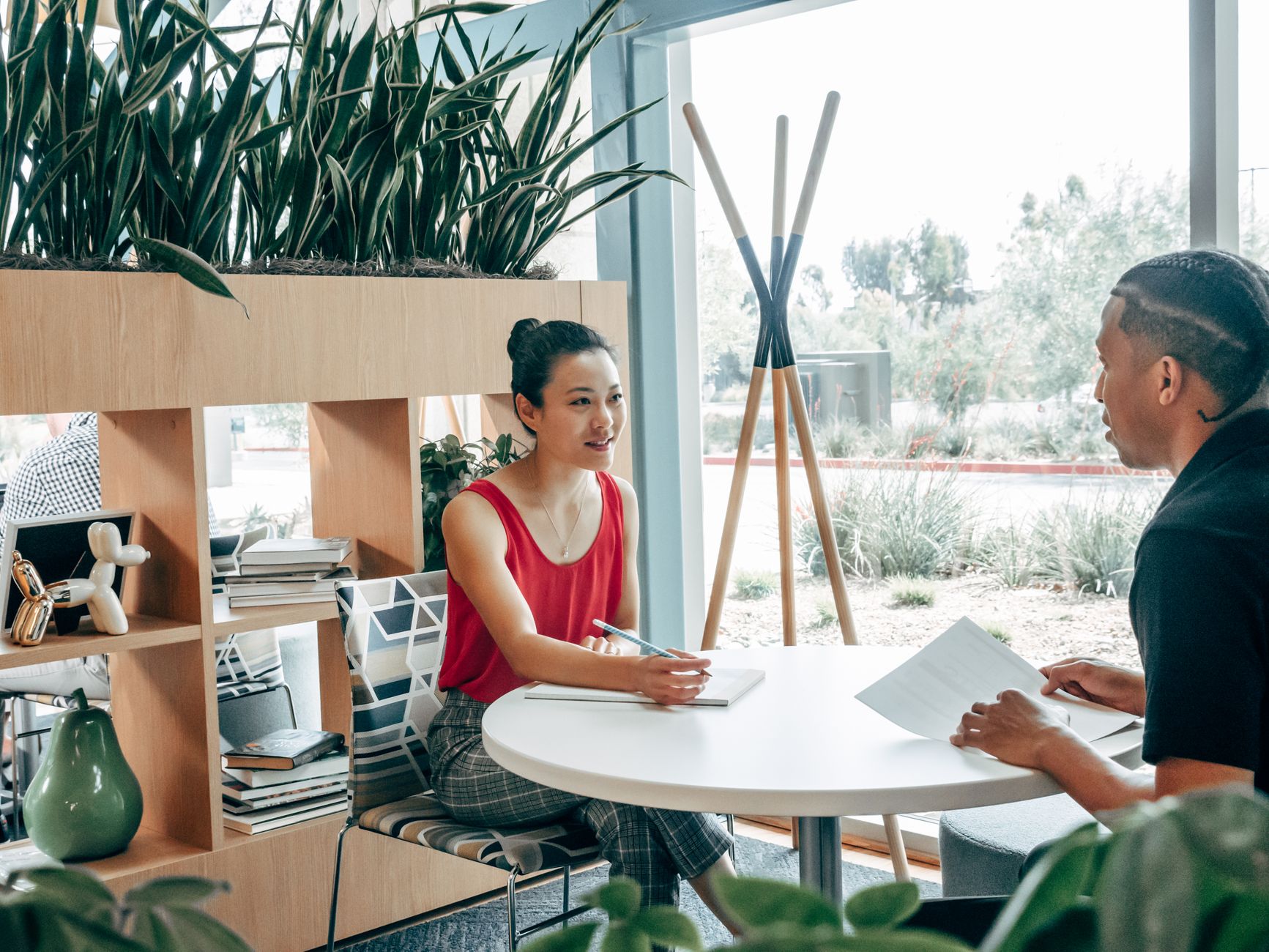 Two coworkers discussing a job opening at an office table