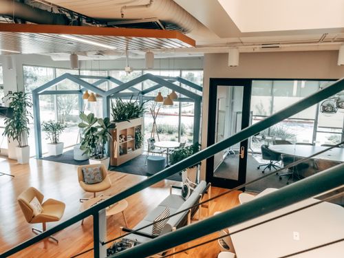 Free Explore a stylish open office design featuring modern furnishings, green plants, and ample natural light. Stock Photo
