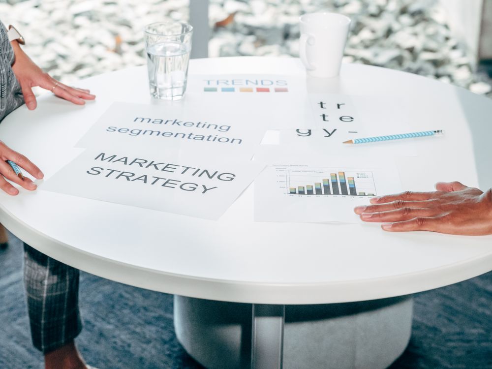 Twee professionals bespreken marketingstrategie aan een overlegtafel