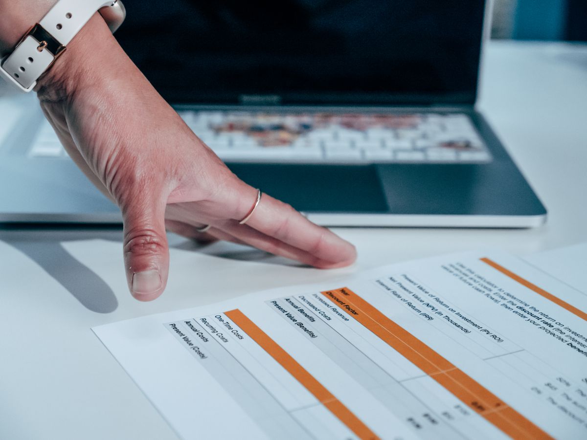 Ecommerce store owner reviewing a social media content budget spreadsheet next to a laptop