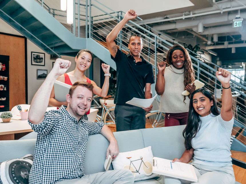 Coworkers celebrating together in a modern office, photo by Kindel Media on Pexels