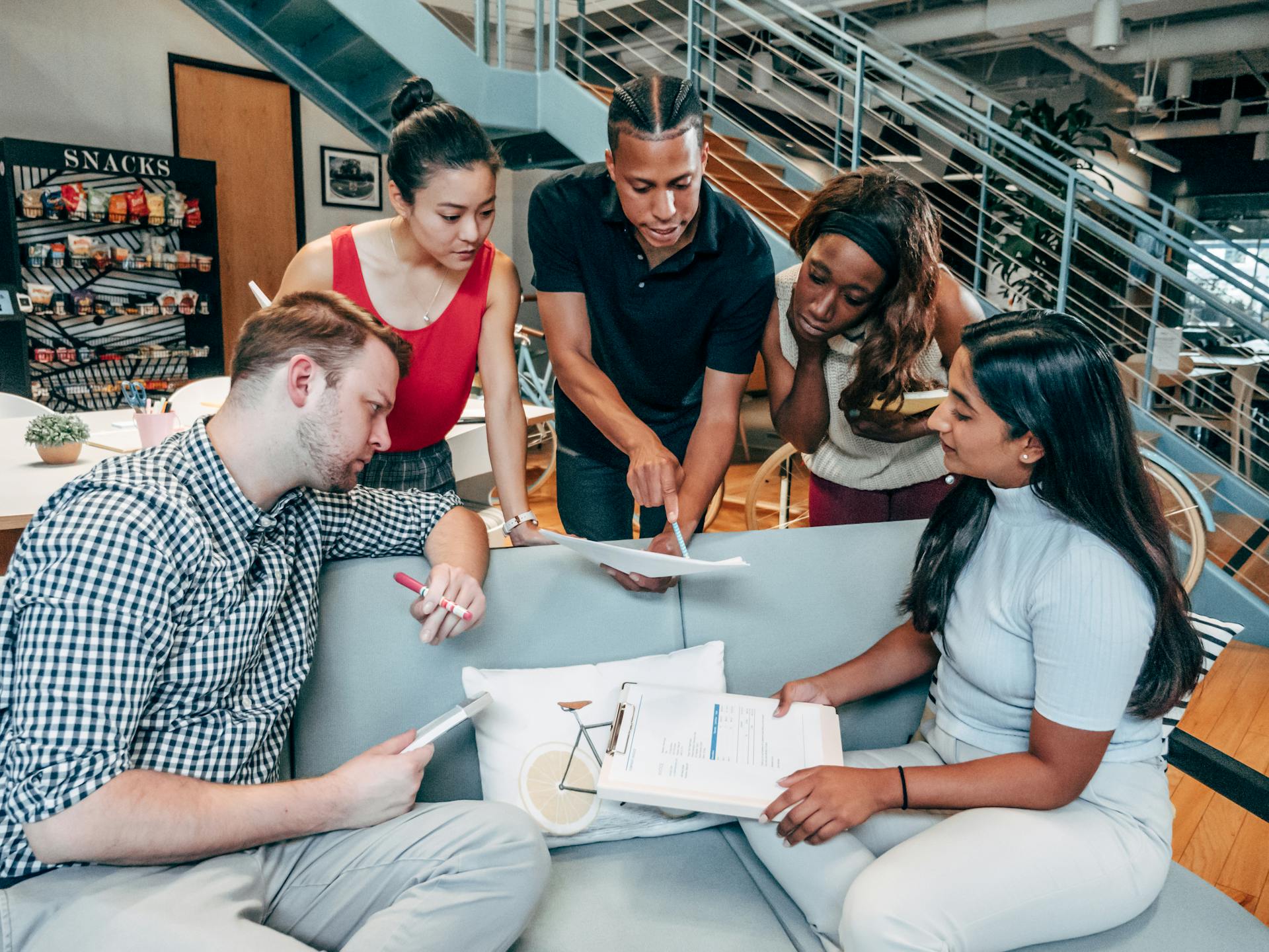 Group of diverse coworkers brainstorming and collaborating in a modern office setting.