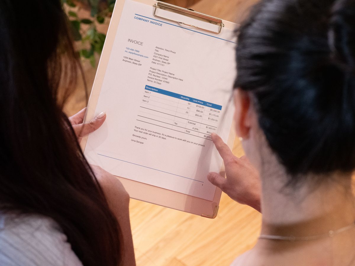 Deux personnes comparant les options sur un document, en réunion de décision