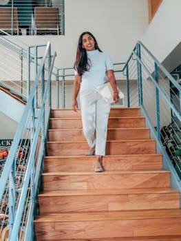 Professional woman descends a staircase in a modern workplace, exuding confidence.
