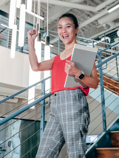 Triumphant Woman standing on Staircase