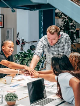A diverse group of colleagues collaborating around a table in a modern office environment, emphasizing teamwork and creativity.