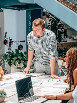 Business meeting with diverse team discussing ideas and strategies in a modern office environment.