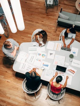 High-angle view of diverse team collaborating on a business project in a modern office.