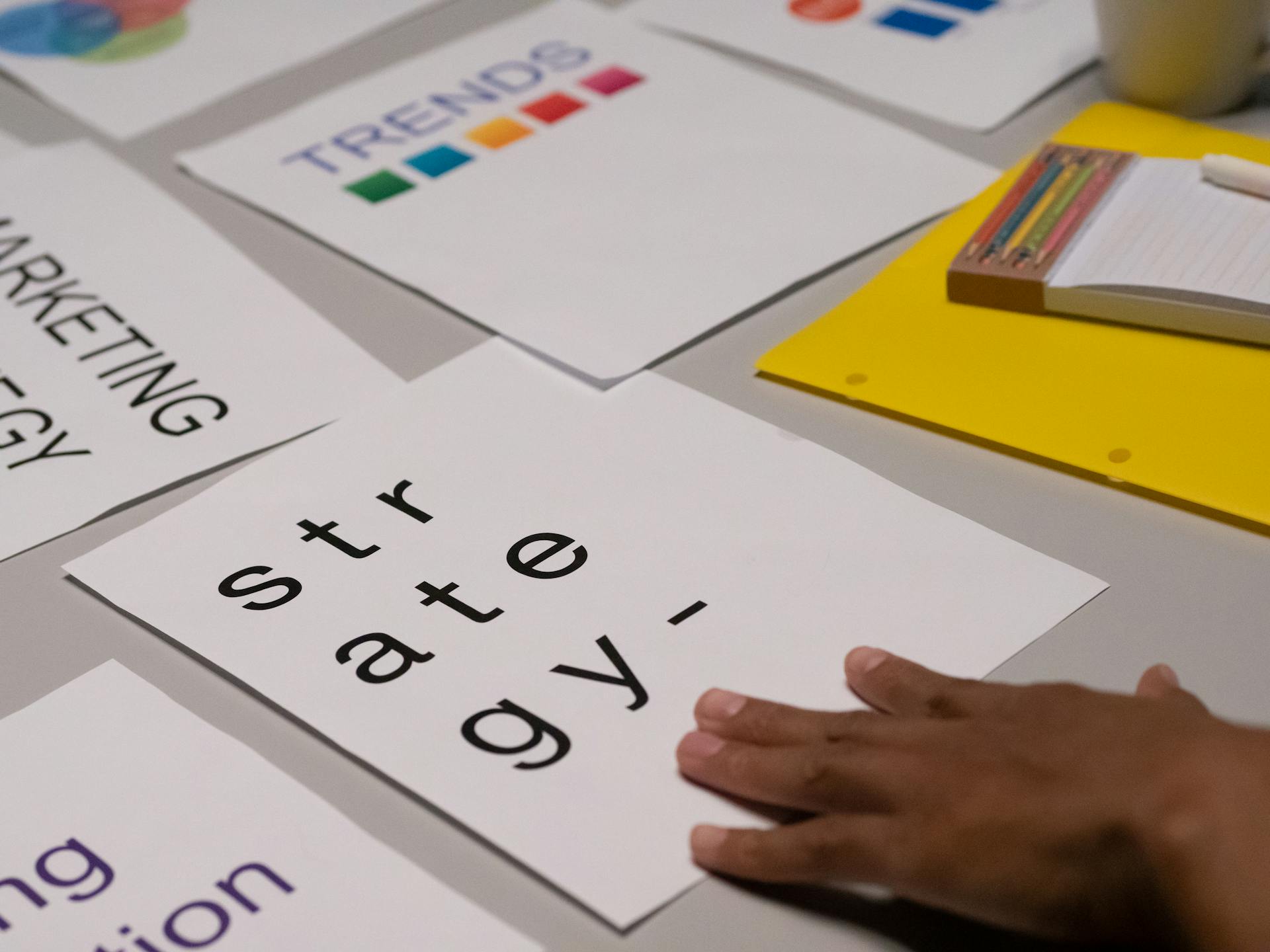 Close-up of marketing strategy notes and colorful trends sheet on a table for planning session.