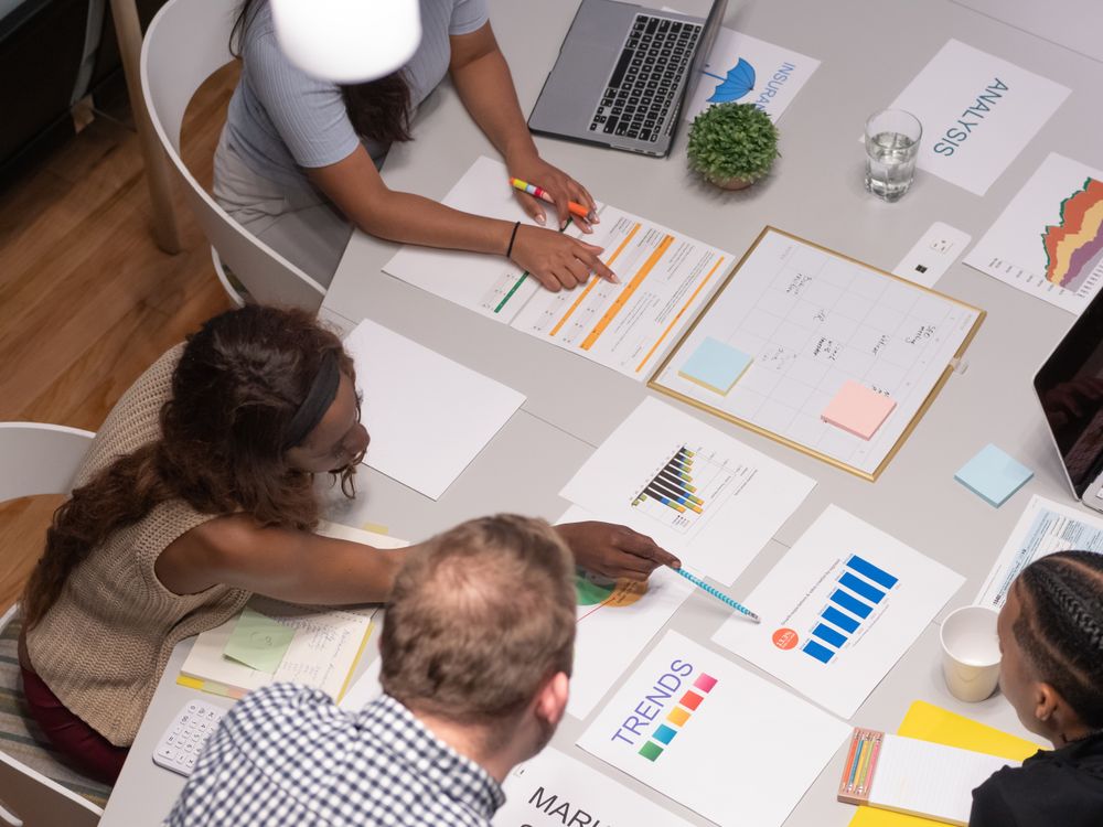 Equipe analisando gráficos e planejando atividades de uma empresa
