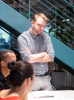 Focused team discussing strategies in a modern office with a manager in a checkered shirt.