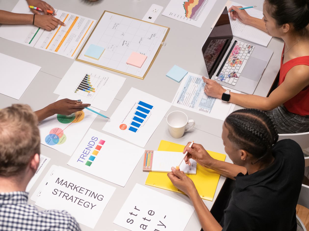 A marketing team reviewing AI visibility and sentiment data on colorful charts during a strategy meeting