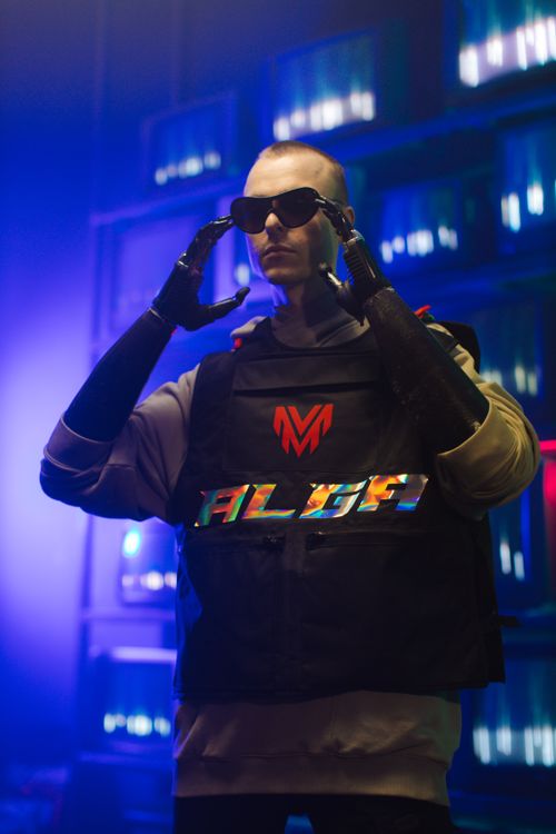 Free Stylish man with prosthetic arms wearing sunglasses in a vibrant, futuristic setting. Stock Photo