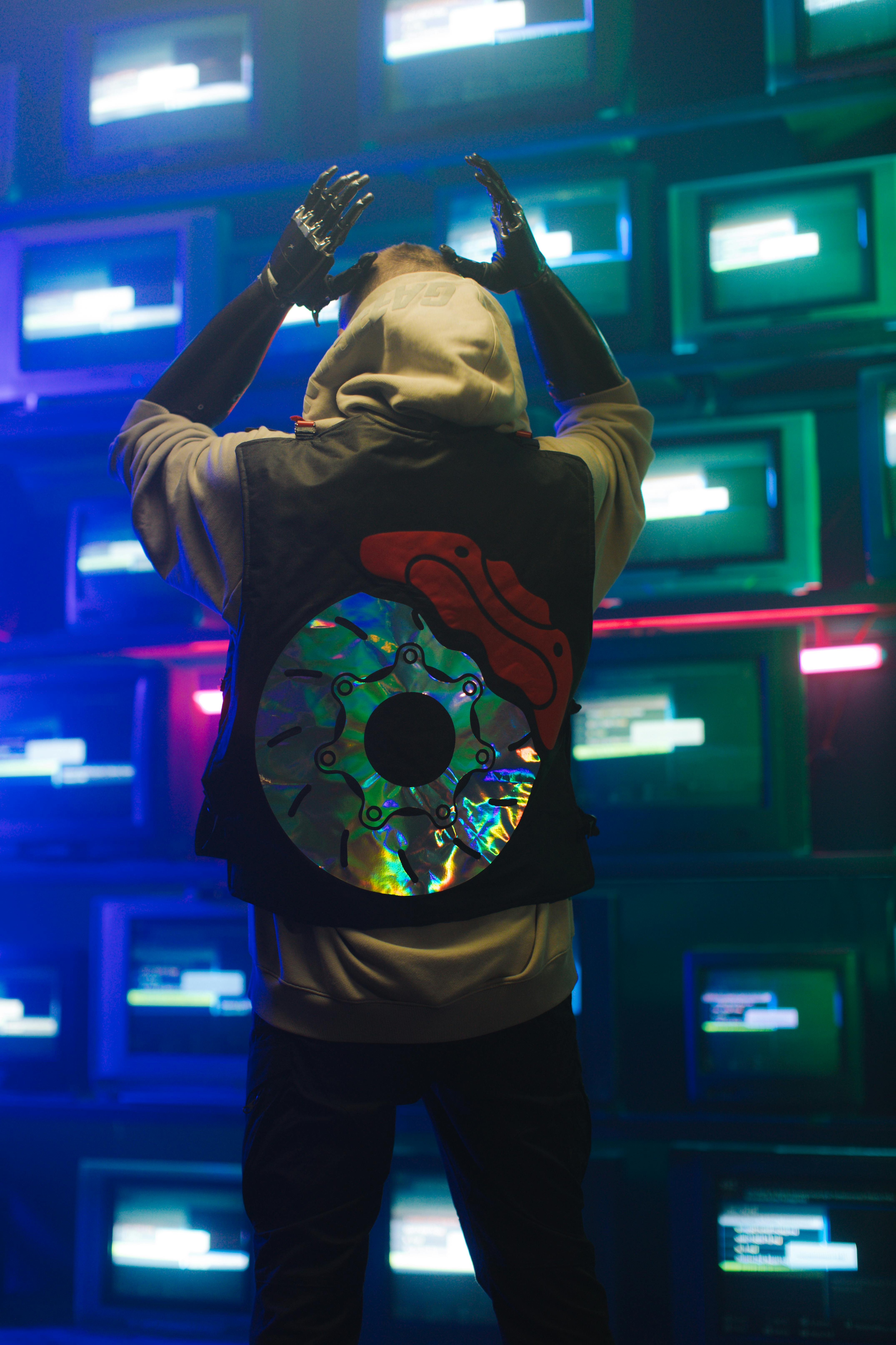 back view of a man facing a wall of television sets