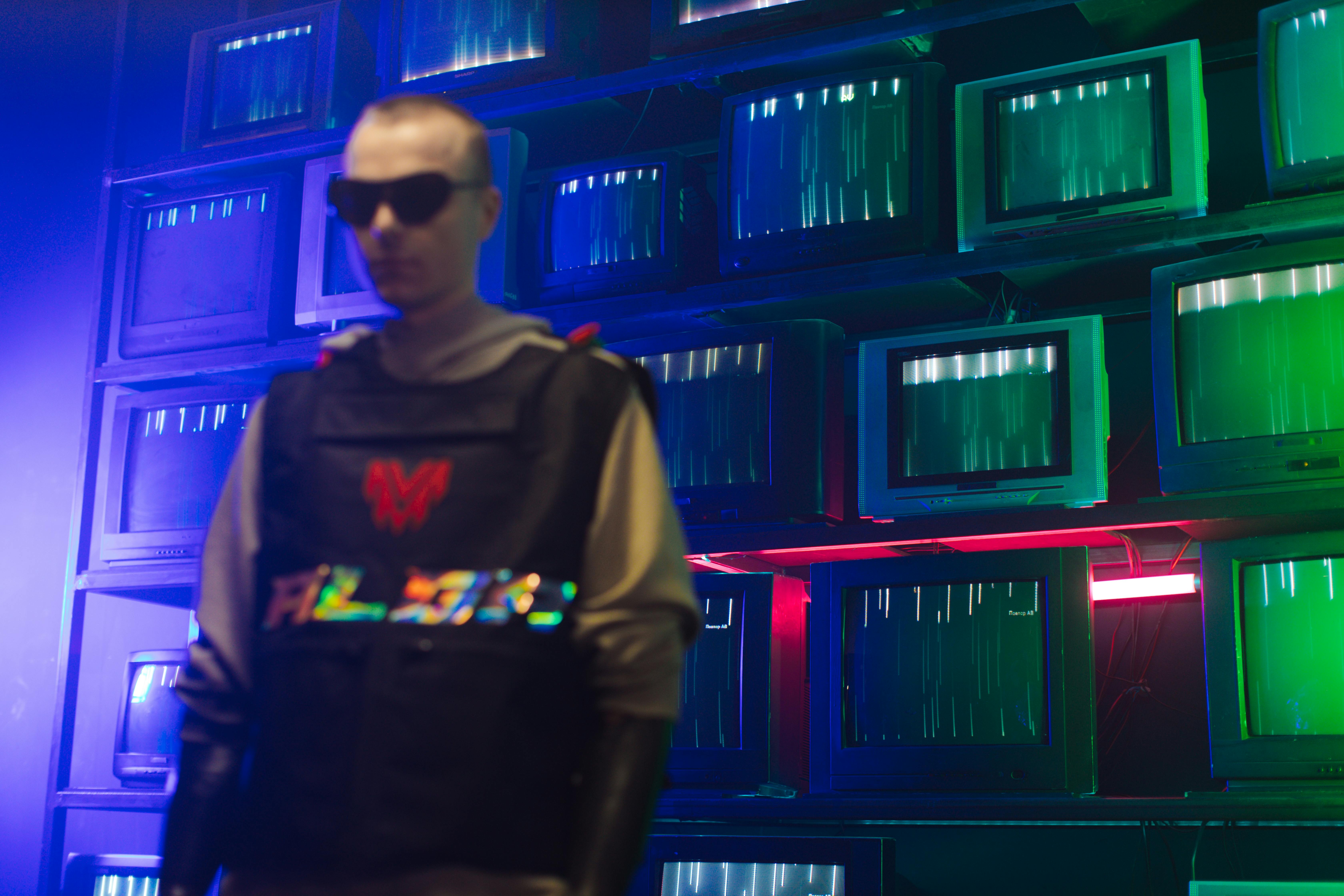 Inteligência Artificial (IA): O motor do futuro digital 2 Futuristic cyberpunk setting with a man in sunglasses and vintage TVs displaying static lights.