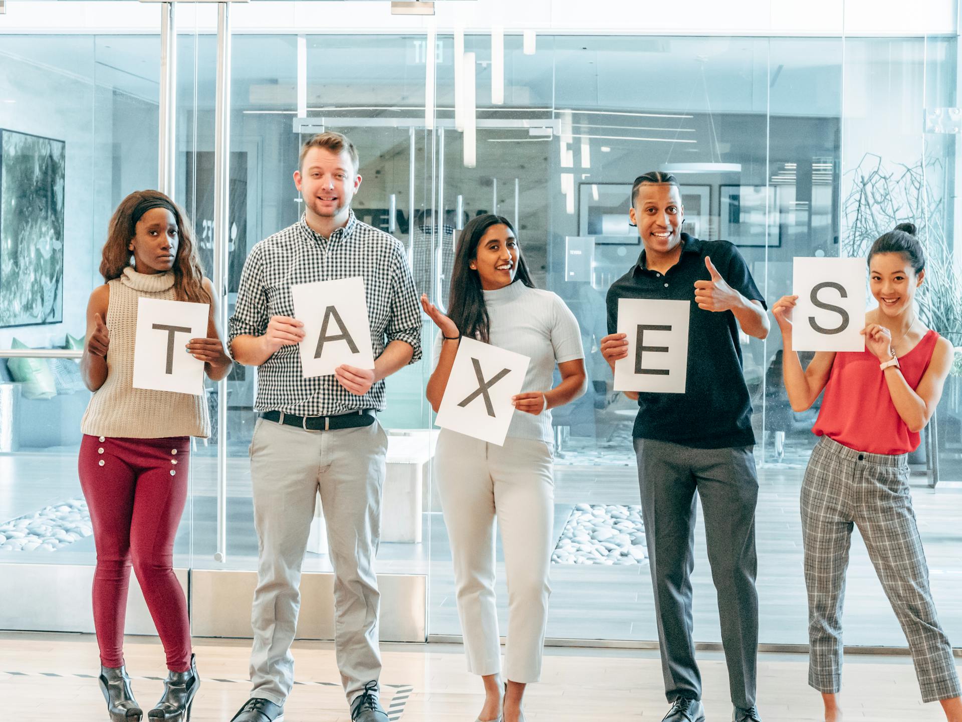 A Group of People Holding Papers with Printed Taxes