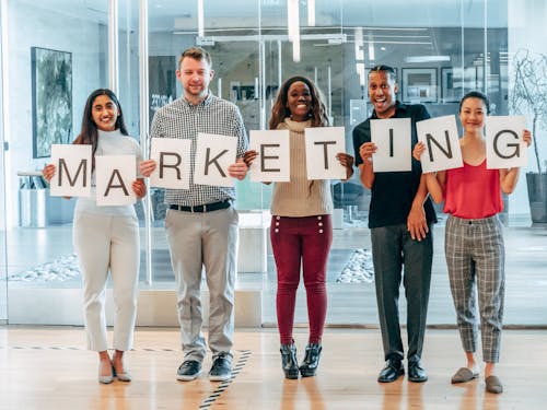 Happy Coworkers Holding up Letters on Pieces of Paper