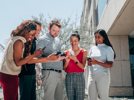 Five adults socializing with smartphones, representing technology and diversity.