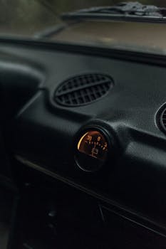 Detailed view of a vintage car dashboard featuring a round gauge. Perfect for automotive enthusiasts.