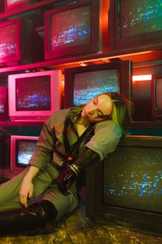 Woman with prosthetic arm resting on vintage CRT monitors with colorful ambient lights.