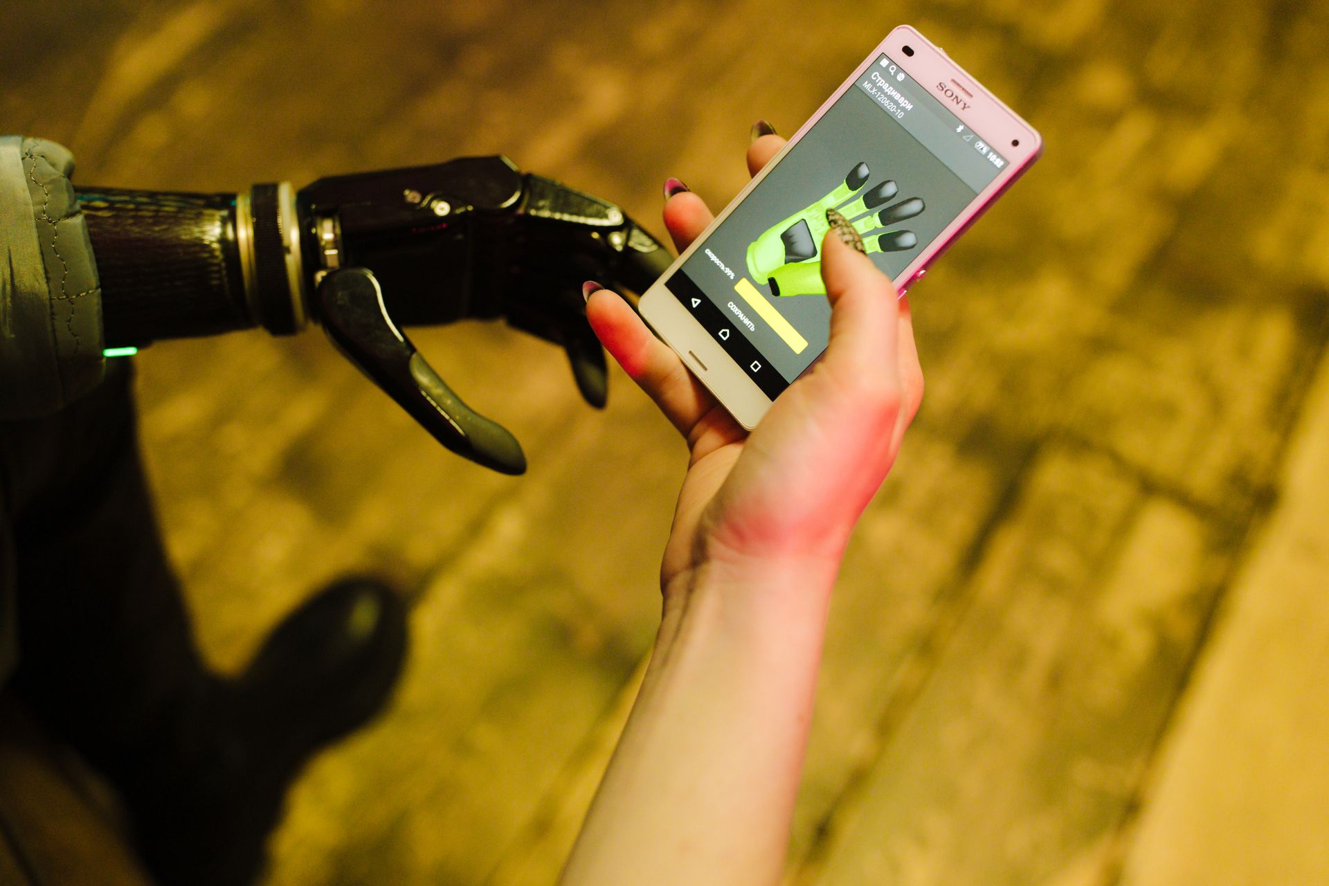 A close-up of a prosthetic hand interacting with a smartphone showcasing futuristic technology.