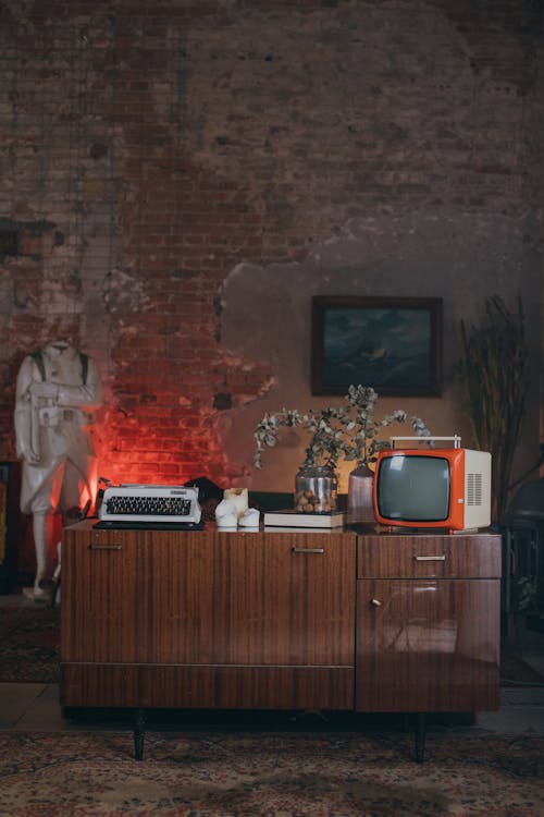 Television and Typewriter on Top of a Wooden Cabinet