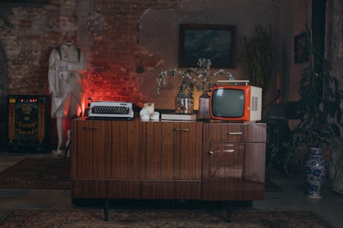 Brown Wooden Cabinet With Vintage Typewriter and Television