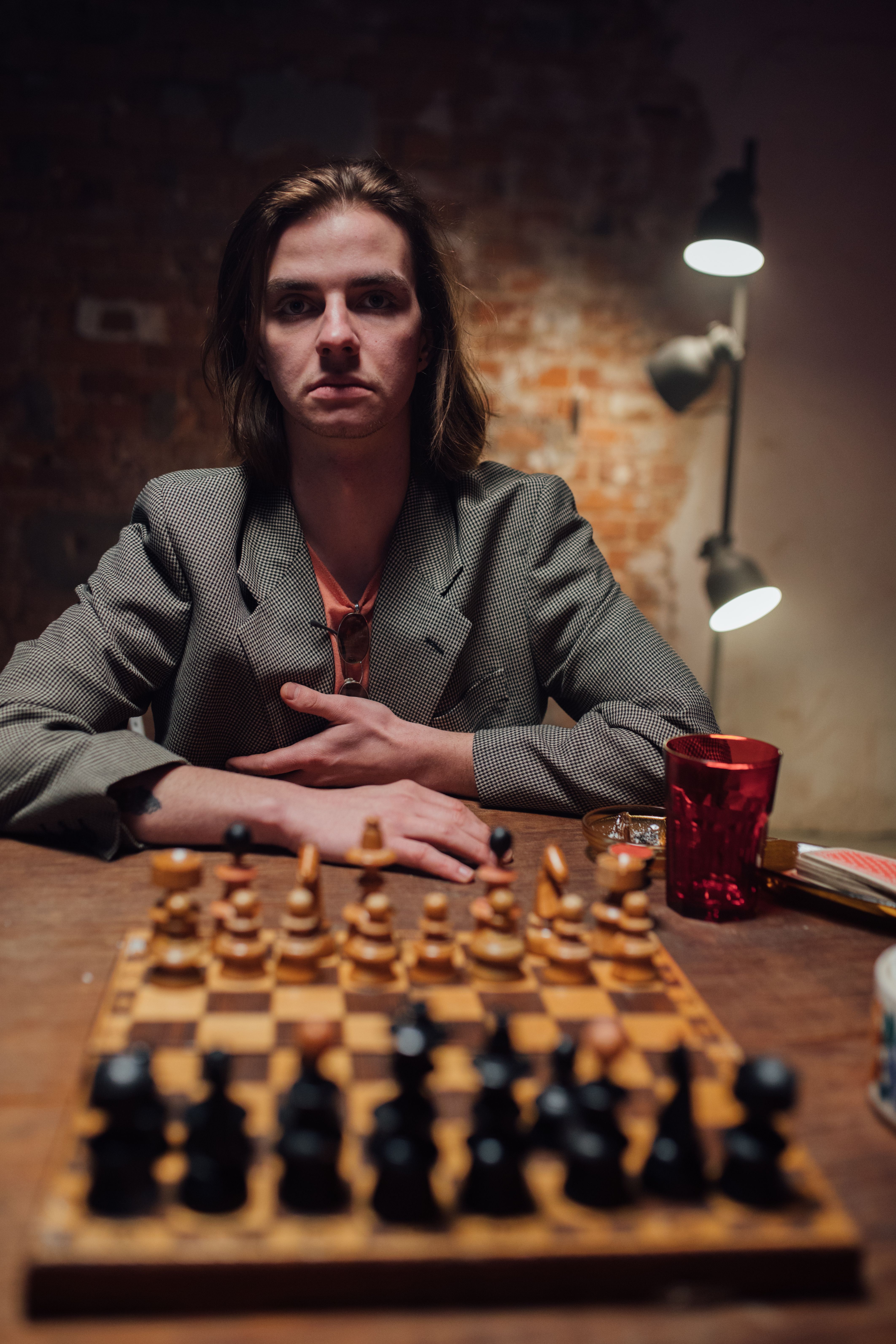 A serious young man playing chess in a vintage setting, creating a focused atmosphere.