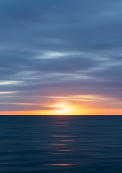 Dramatic sunset over the ocean with vibrant colors in Rostock, Germany.