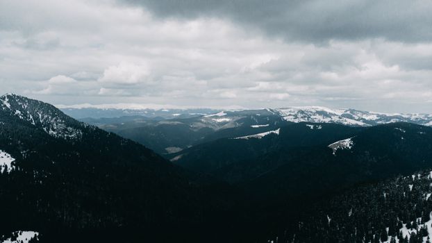 Majestic snowy mountains in Zakarpattia Oblast under cloudy winter skies.