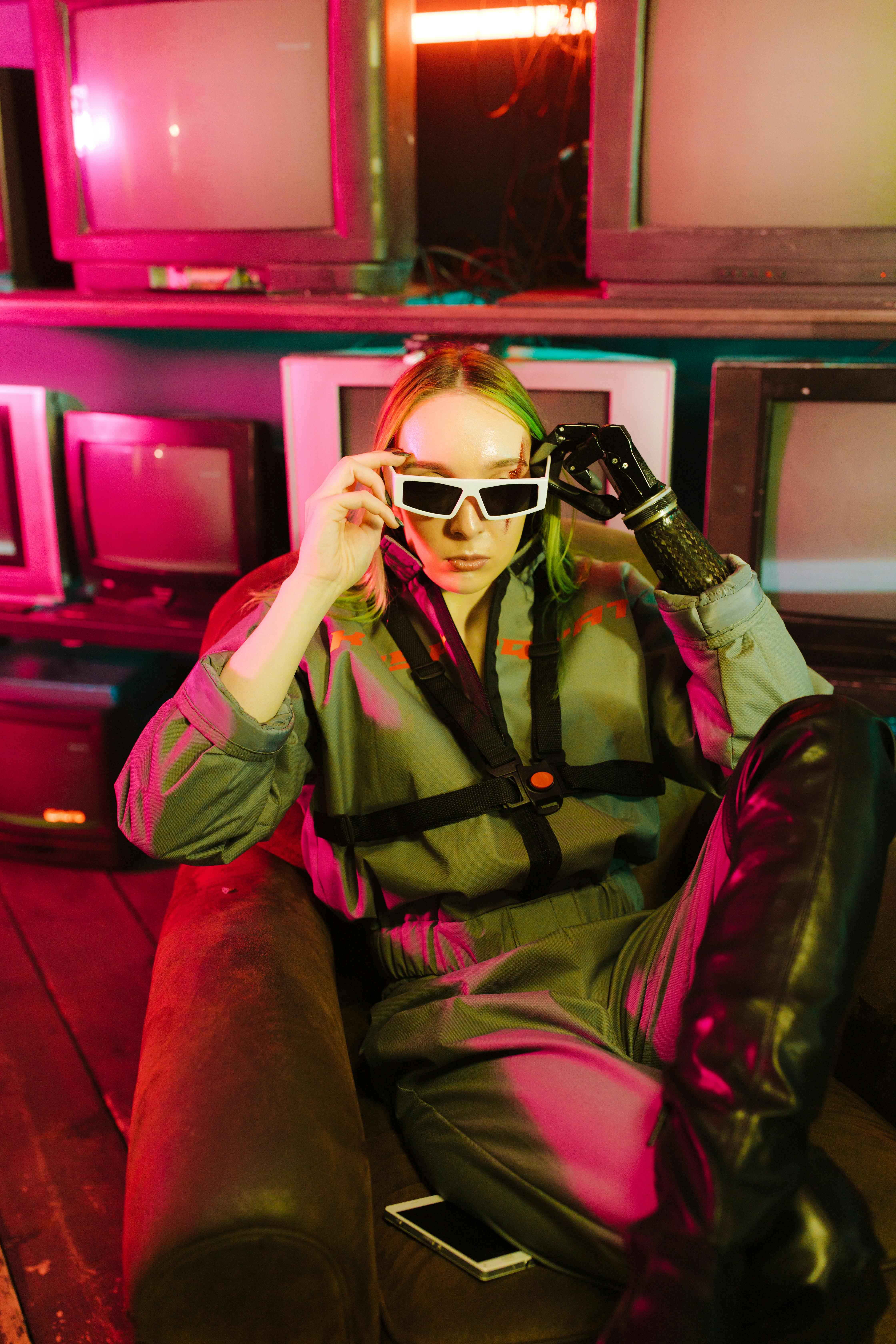 Cyberpunk-themed image of a person in futuristic attire surrounded by vintage TVs with neon lighting.