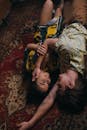 Woman in Green and Brown Camouflage Shirt Lying on Red and Brown Floral Area Rug