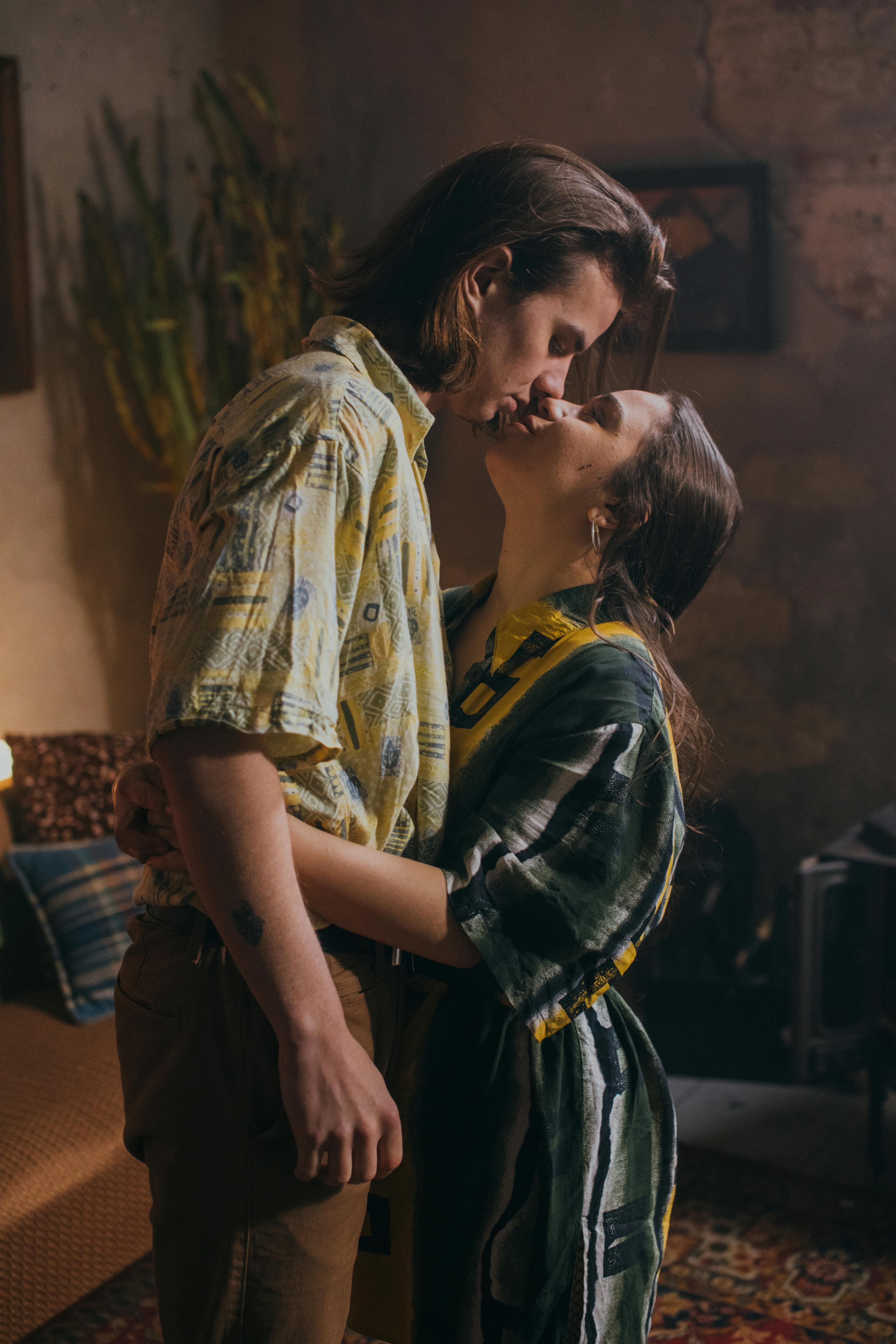 Sensual couple embracing with intense eye contact, bodies pressed close