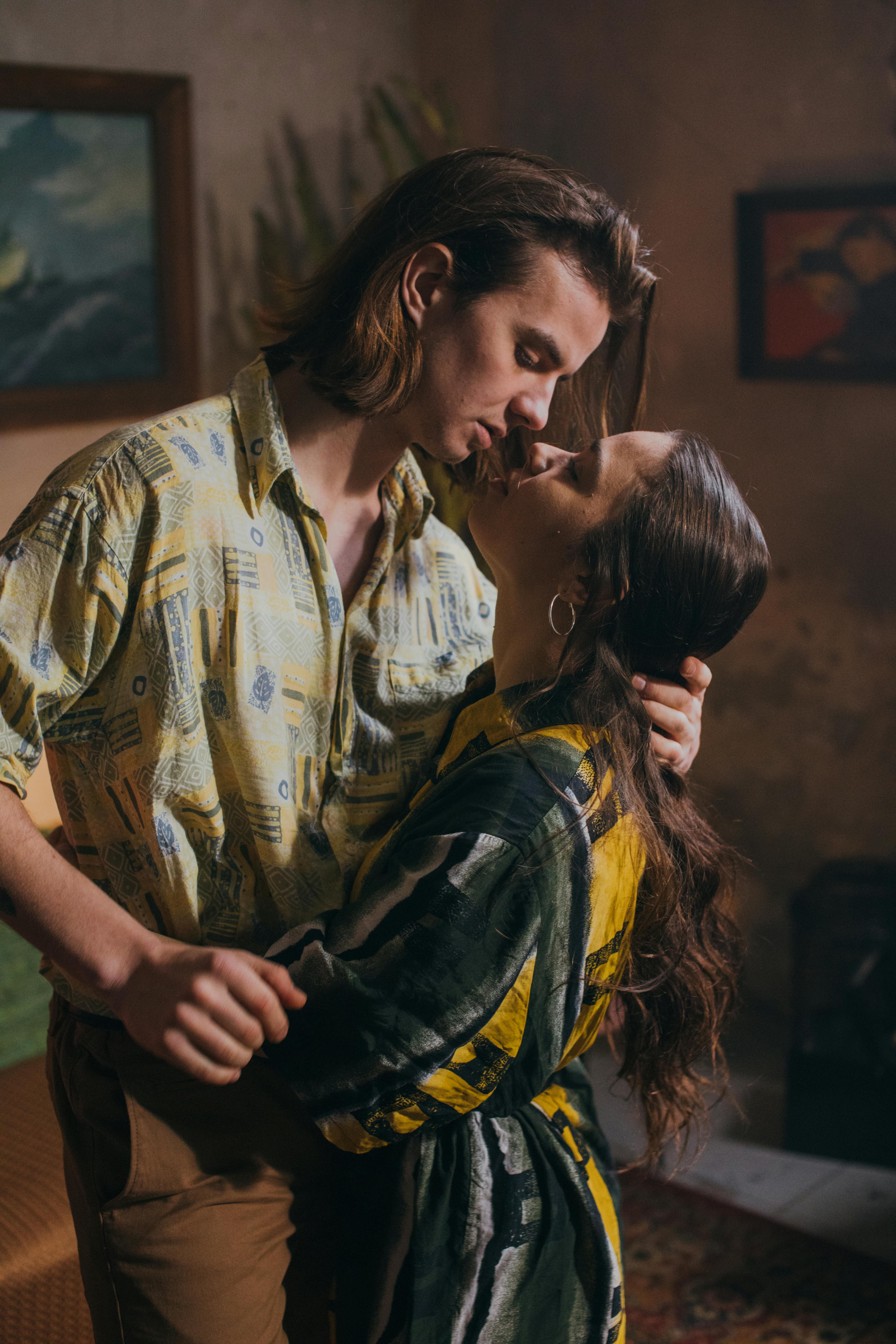 Couple sharing an intimate moment in a cozy indoor setting, expressing love.
