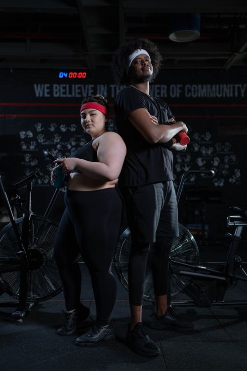 Free Two confident individuals embracing fitness and diversity in a gym setting. Stock Photo