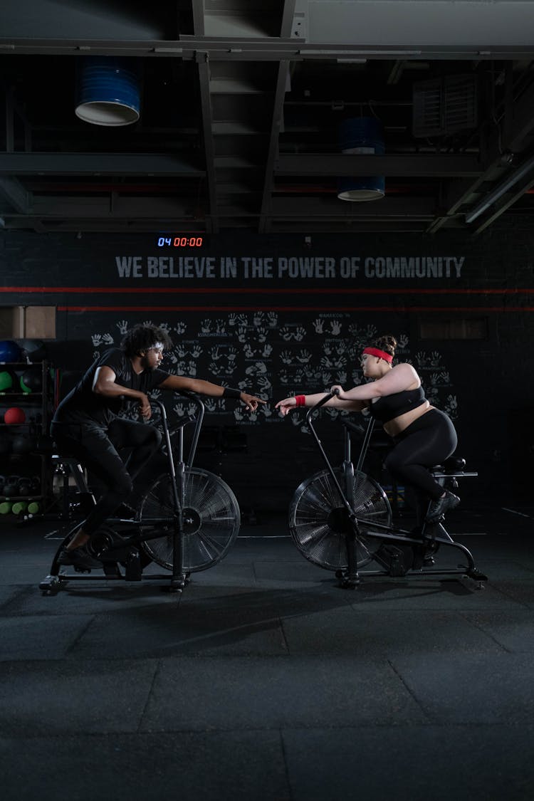 Man And Woman Exercising Using A Stationary Bicycle