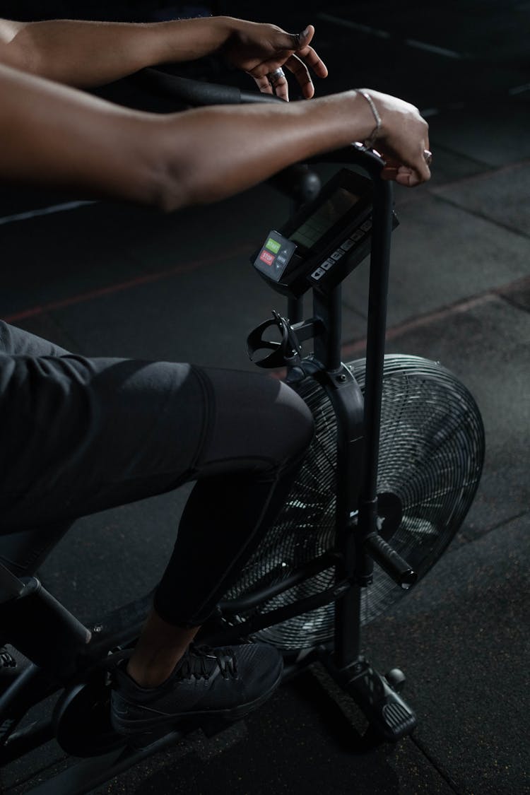 Person In Black Pants Using A Stationary Bicycle