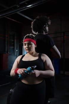 Two individuals in activewear at the gym, embracing fitness and positivity.