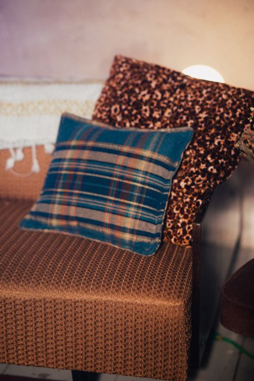 Free Comfortable sofa with plaid and leopard print throw pillows creating a cozy atmosphere. Stock Photo