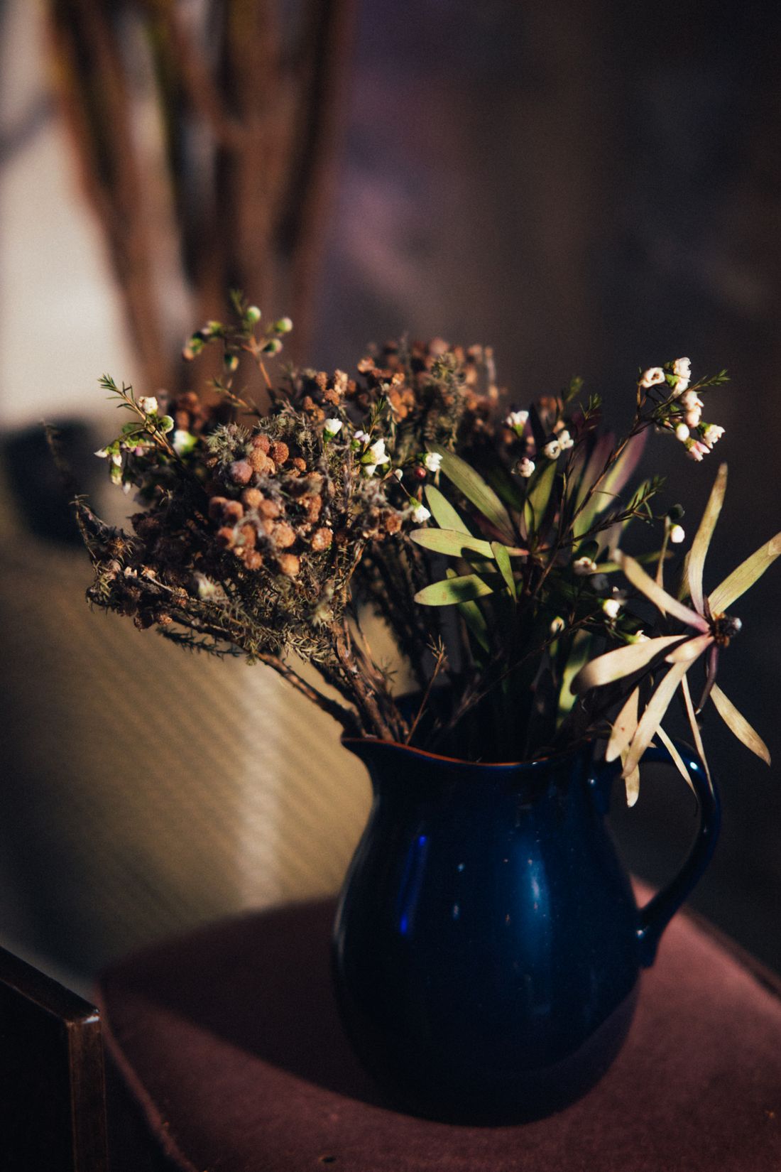 Dried flowers and grasses in a blue ceramic jug