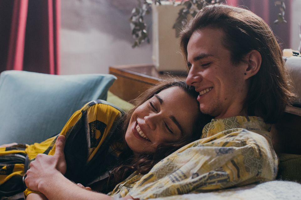 A couple embracing and smiling on a couch