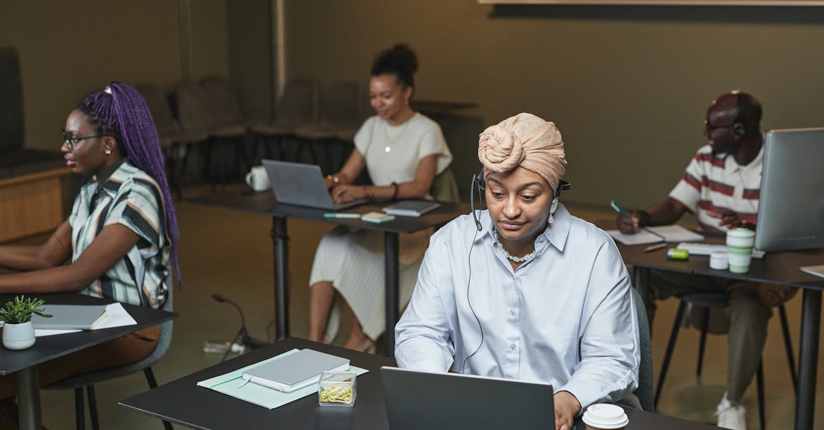diverse group of people writing on laptops in a cozy cafe with natural lighting